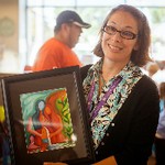 Director of Cook Library Center holds up an art piece